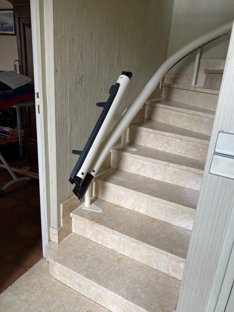 Rail relevable automatique d'un monte-escalier courbe électrique installé à Chelles dans le 77